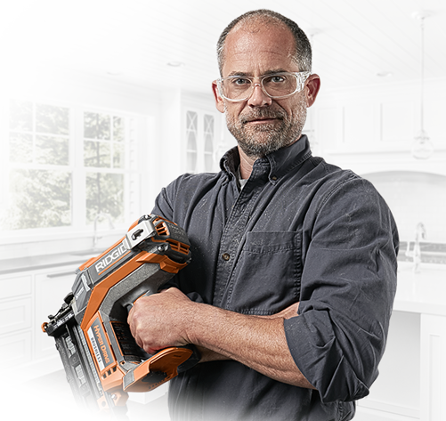 Background Image: Man Holding a Ridgid Brad Nailer